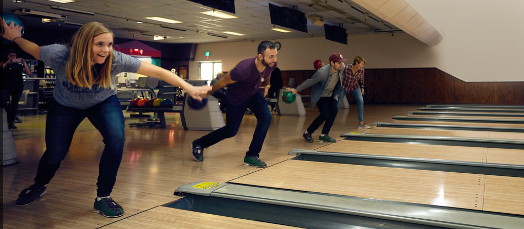Group of people bowling at their company party.