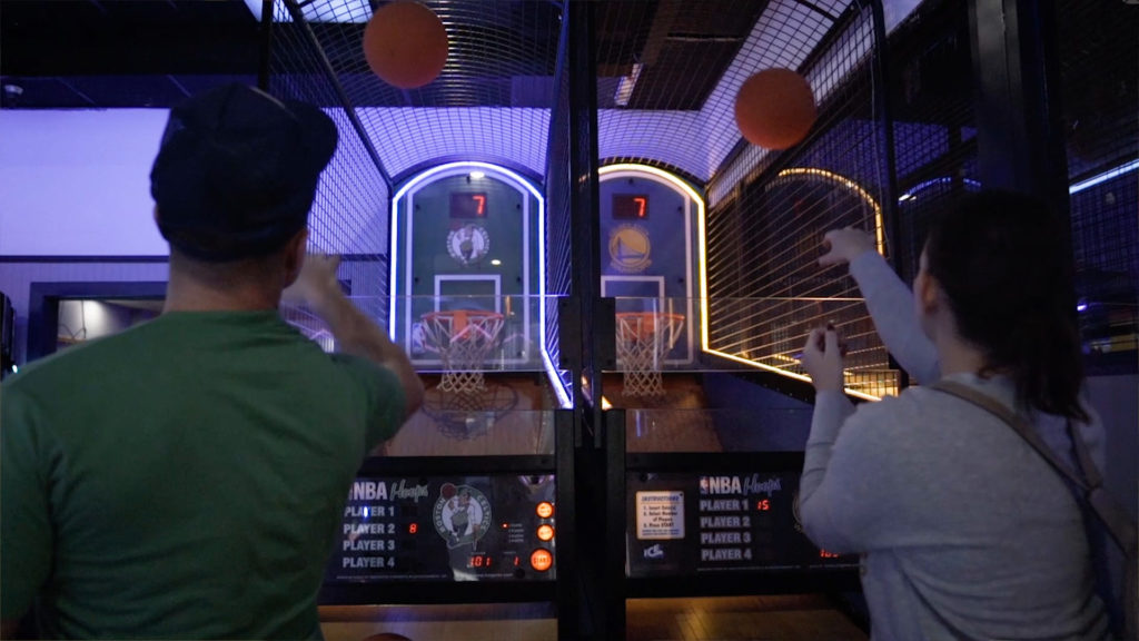 People playing a basketball arcade game